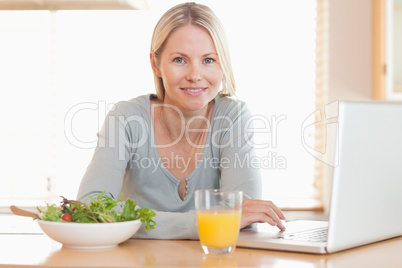 Woman having healthy lunch while working on her notebook