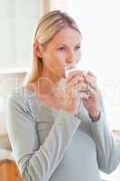 Woman drinking a glass of water in the kitchen