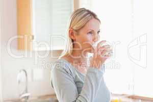 Woman in the kitchen drinking some water