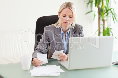 Businesswoman comparing bills