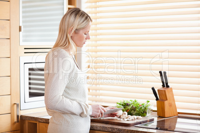 Side view of woman slicing ingredients for her salad