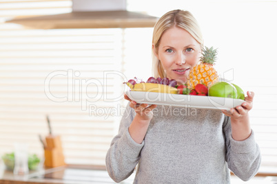 Woman holding a plate of fruits