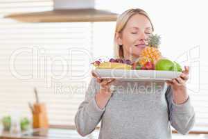 Woman smelling on her fruit plate