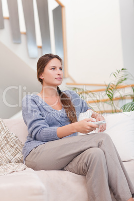 Portrait of a young woman watching TV