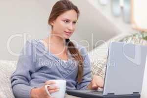 Woman using a laptop while having a coffee
