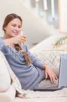 Portrait of a woman having a glass of wine during a video confer