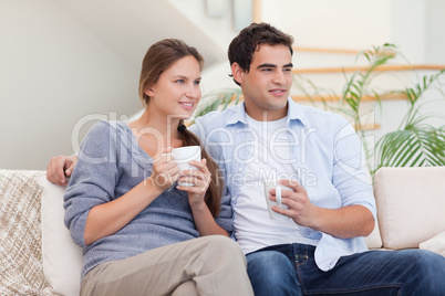 Couple watching TV while drinking tea