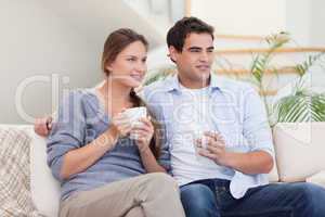 Couple watching TV while drinking tea
