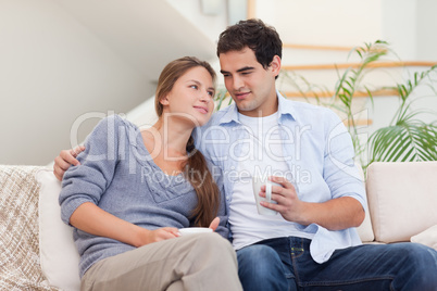 Couple watching TV while drinking coffee