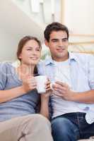 Portrait of a couple drinking coffee while watching TV