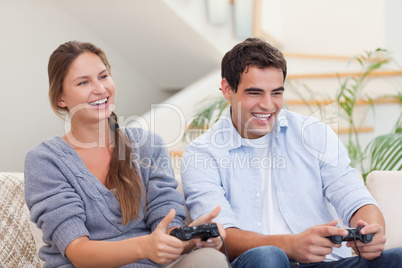 Smiling couple playing video games