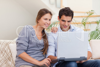 Smiling couple using a laptop