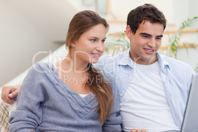 Joyful couple using a laptop