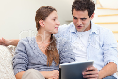 Engaged couple using a tablet computer