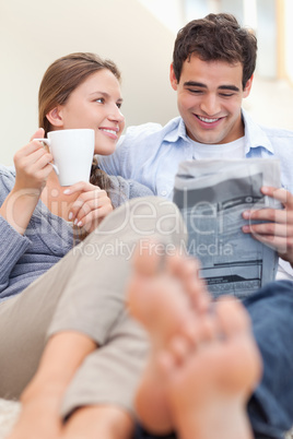 Portrait of a smiling couple reading a newspaper in the morning