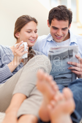 Portrait of a happy couple reading a newspaper in the morning