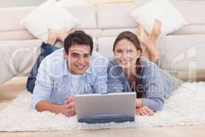 Cute couple posing with a laptop