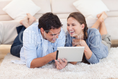 Delighted couple using a tablet computer