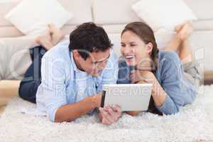 Delighted couple using a tablet computer
