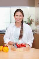 Portrait of a woman slicing a pepper