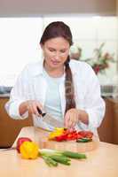 Portrait of a young woman slicing a pepper