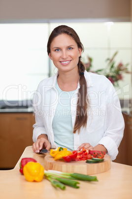 Portrait of a lovely woman slicing a pepper