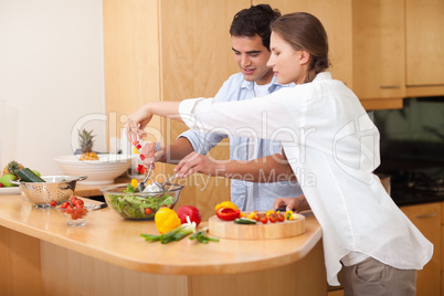 Happy couple preparing a salad