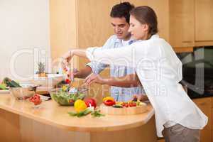 Happy couple preparing a salad