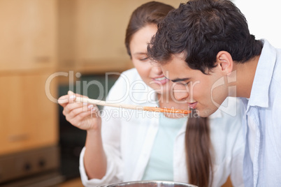 Close up of a man trying his wife's sauce