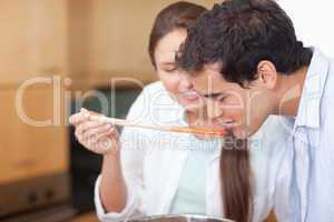 Close up of a man trying his wife's sauce