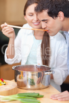 Portrait of a young man trying his wife's sauce