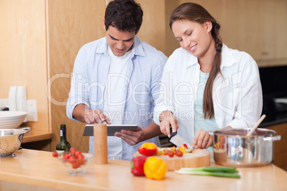 Couple using a tablet computer to cook