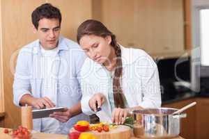 Modern couple using a tablet computer to cook