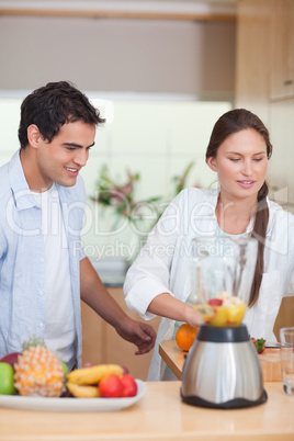 Portrait of a young couple making fresh fruits juice