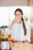 Portrait of a cute woman drinking fresh fruits juice