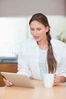 Portrait of a woman using a tablet computer while drinking tea