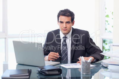 Businessman working with a laptop and a graph