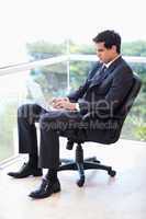 Portrait of a businessman sitting on an armchair working with a