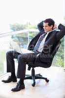 Portrait of a relaxed businessman sitting on an armchair working