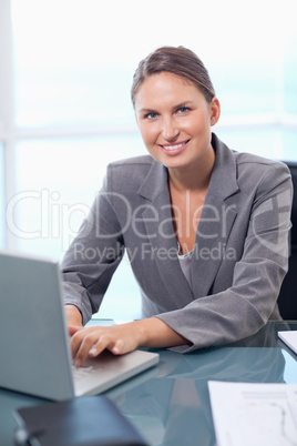 Portrait of a smiling businesswoman working with a laptop