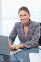 Portrait of a smiling businesswoman working with a laptop