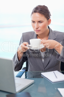 Portrait of a serious businesswoman drinking tea