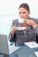 Portrait of a serious businesswoman drinking coffee