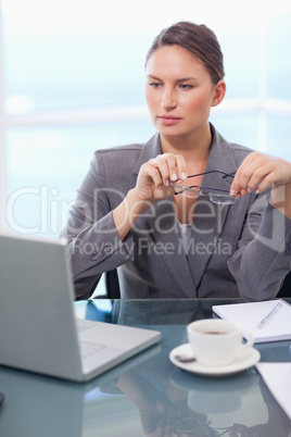 Portrait of a businesswoman putting her glasses on