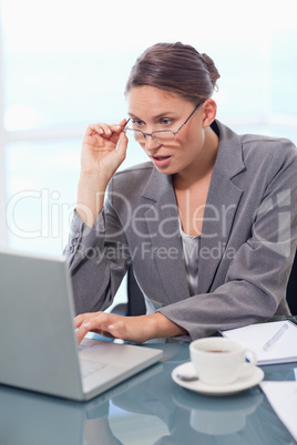 Portrait of a chocked businesswoman using a laptop