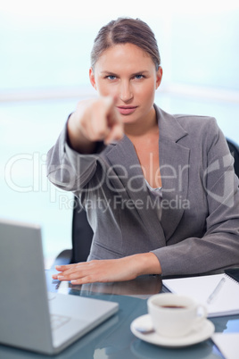 Portrait of a young businesswoman pointing at the viewer