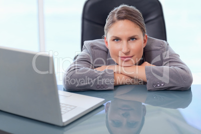Businesswoman leaning on her desk