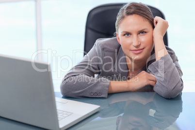 Young businesswoman leaning on her desk