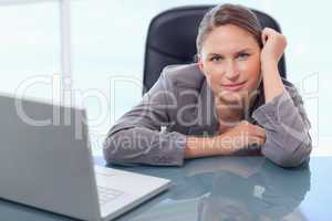 Young businesswoman leaning on her desk