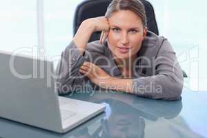 Beautiful businesswoman leaning on her desk